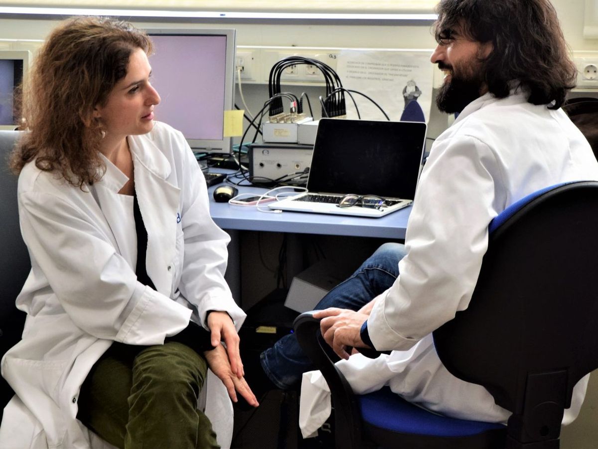 Nazareth Castellanos y Gustavo G. Díez conversan con bata junto a los equipos de registro del laboratorio.